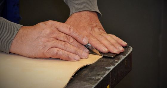 作業台で革製品を仕上げる職人の手元